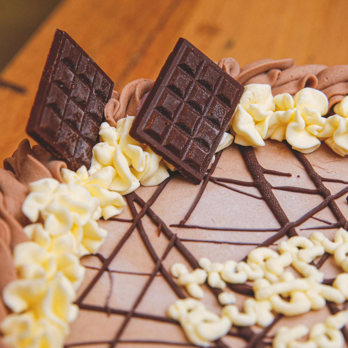 Close-up view of miniature chocolate bar decorations on a handcrafted birthday ice cream cake.