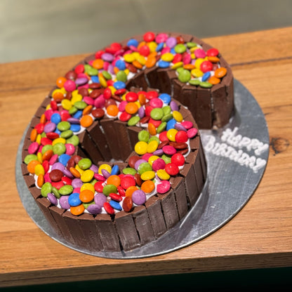 side view of a number 6 birthday cake made with Ben & Jerry's ice cream in Adelaide, showcasing its Kit Kat and Smarties decorations.