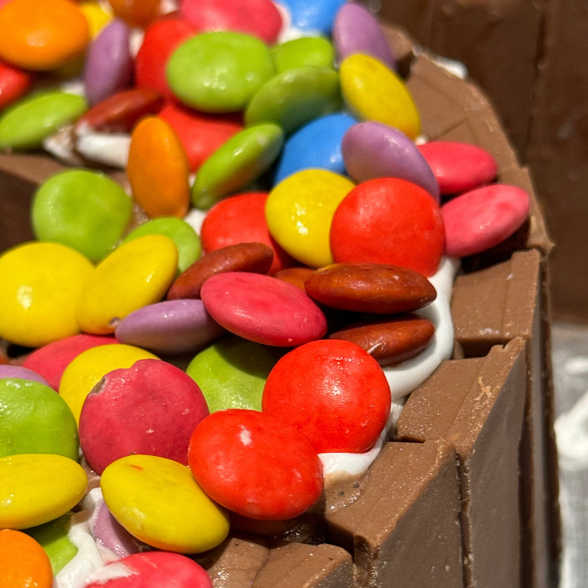 close up of a handcrafted number six ice cream cake in Adelaide made using Ben & Jerry's ice cream, highlighting its chocolate and candy details.