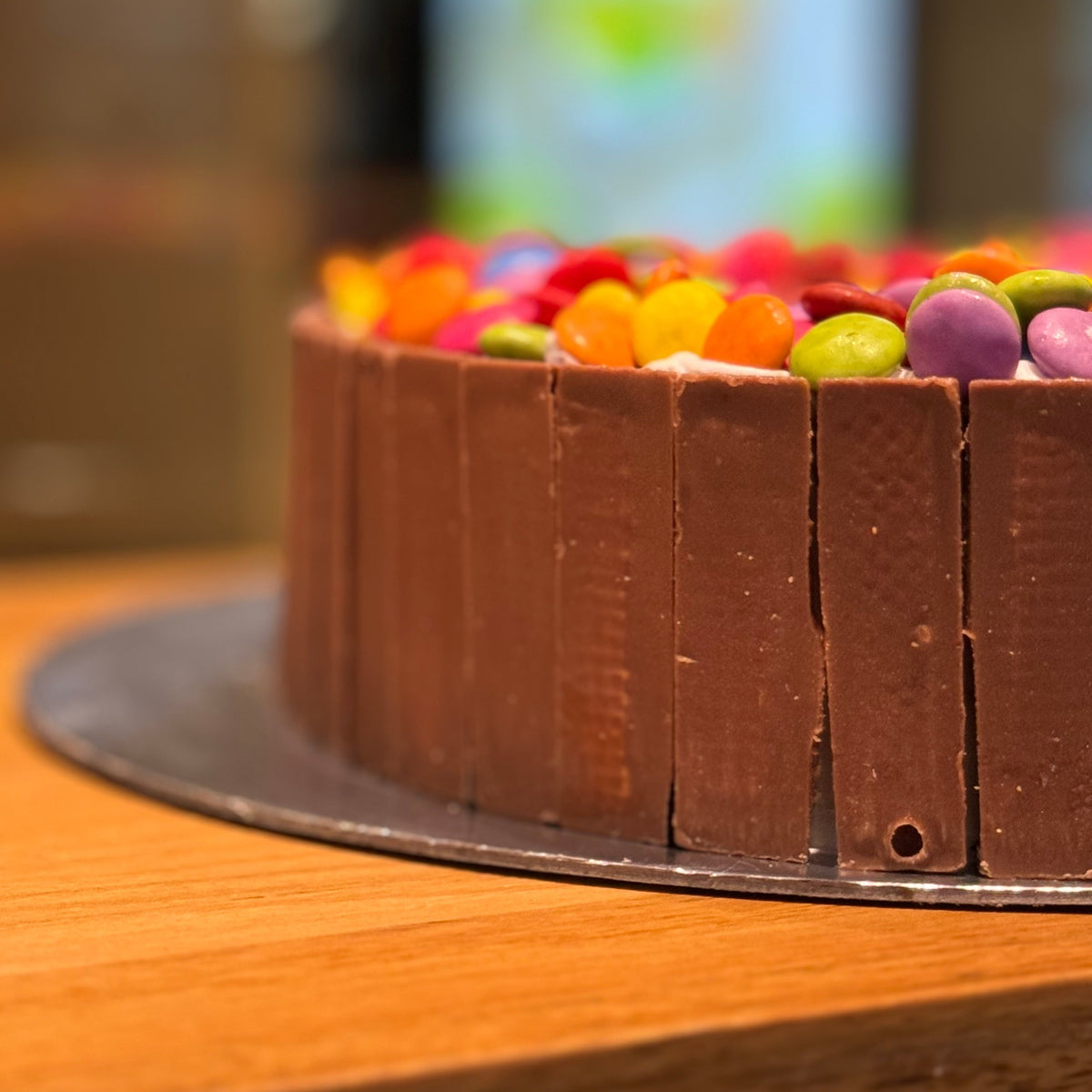Close-up of Kit Kat chocolate and colourful Smarties decorating a number six birthday cake handcrafted in Adelaide using Ben & Jerry's ice cream.