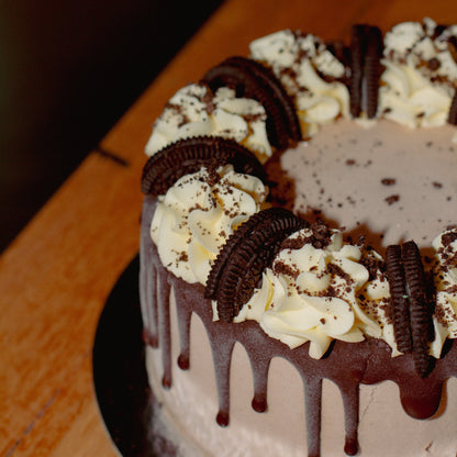close up of an Oreo chocolate birthday ice cream cake showcasing its decorative chocolate drip finish and Oreo cookie toppings.