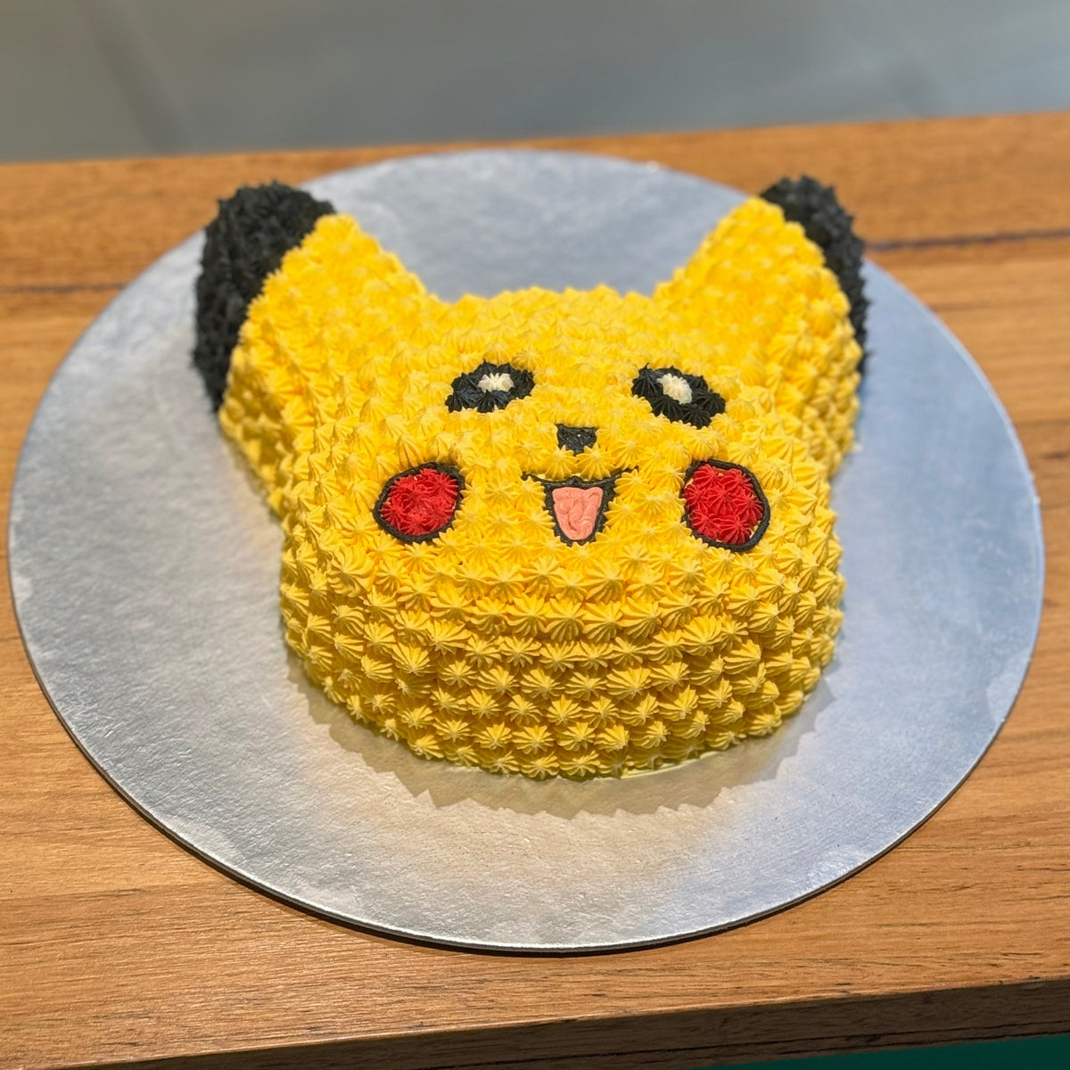 Full view of a Pikachu-shaped Pokémon birthday cake handcrafted in Adelaide using Ben & Jerry's ice cream, featuring the character's signature yellow design.