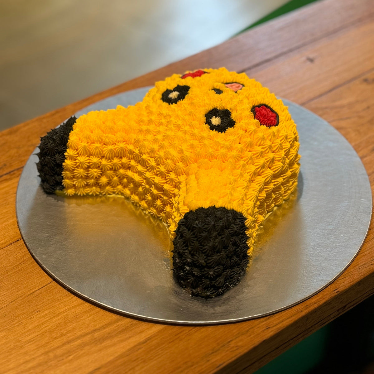 Close-up of Pikachu's playful facial features and pointed ear decorations on a birthday cake handcrafted in Adelaide using Ben & Jerry's ice cream.