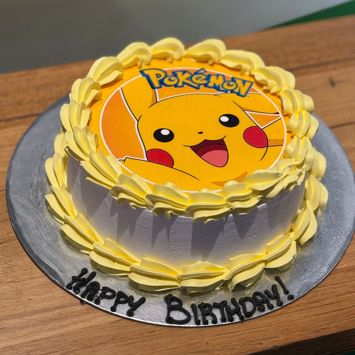 side view of a Pikachu-themed ice cream cake showcasing its cheerful Pokémon character-inspired birthday decorations.