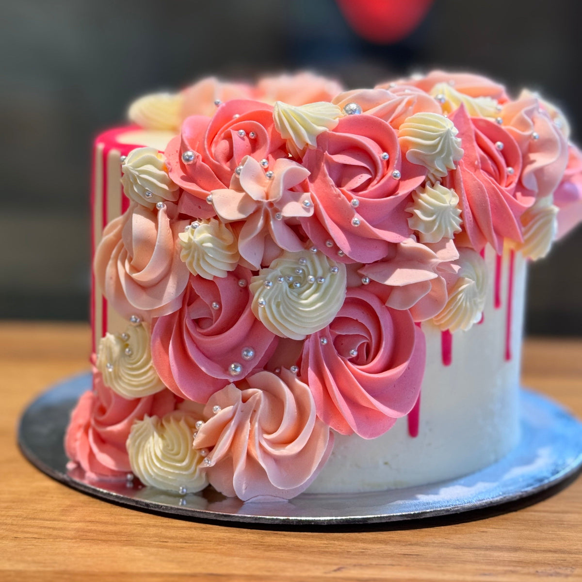 Front view of a pink and white cascading cake in Adelaide, showcasing its flowing decorative details and silver pearl accents.