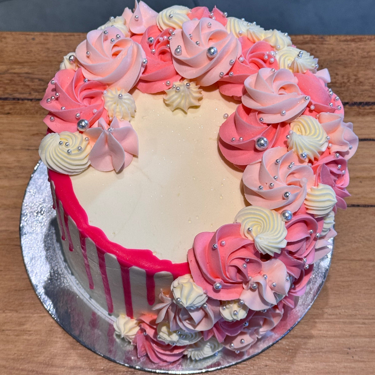 top view of a handcrafted mud or sponge cake in Adelaide, highlighting its soft pastel colours and cascading silver pearl details.