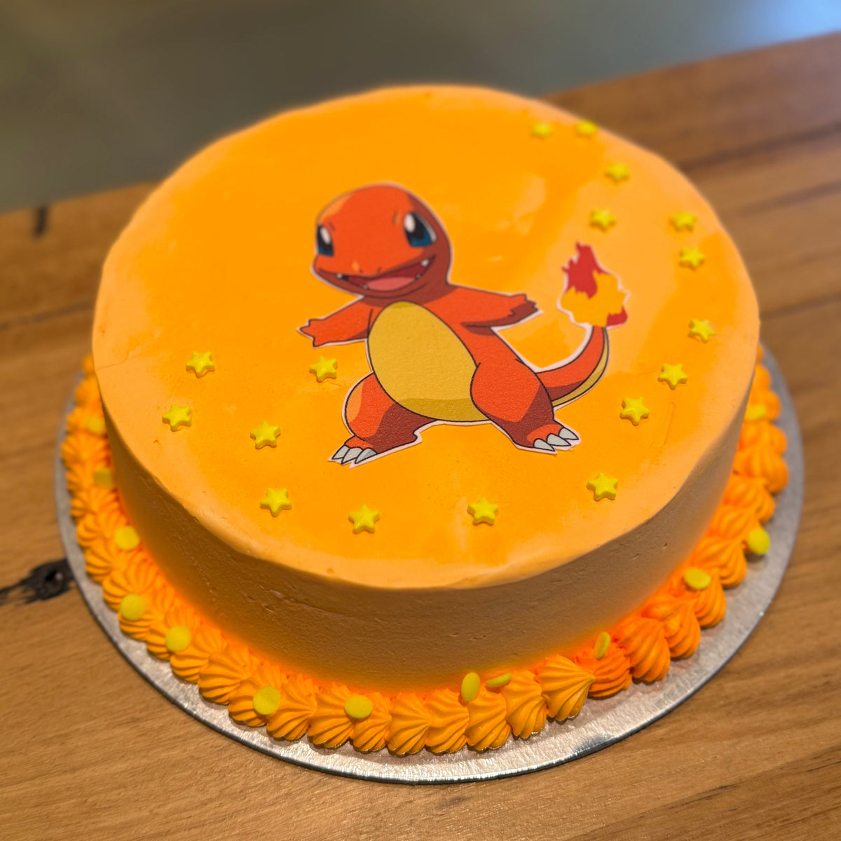 Full view of a Pokémon Charmander birthday cake handcrafted in Adelaide using Ben & Jerry's ice cream, featuring a cheerful orange Fire-type theme.