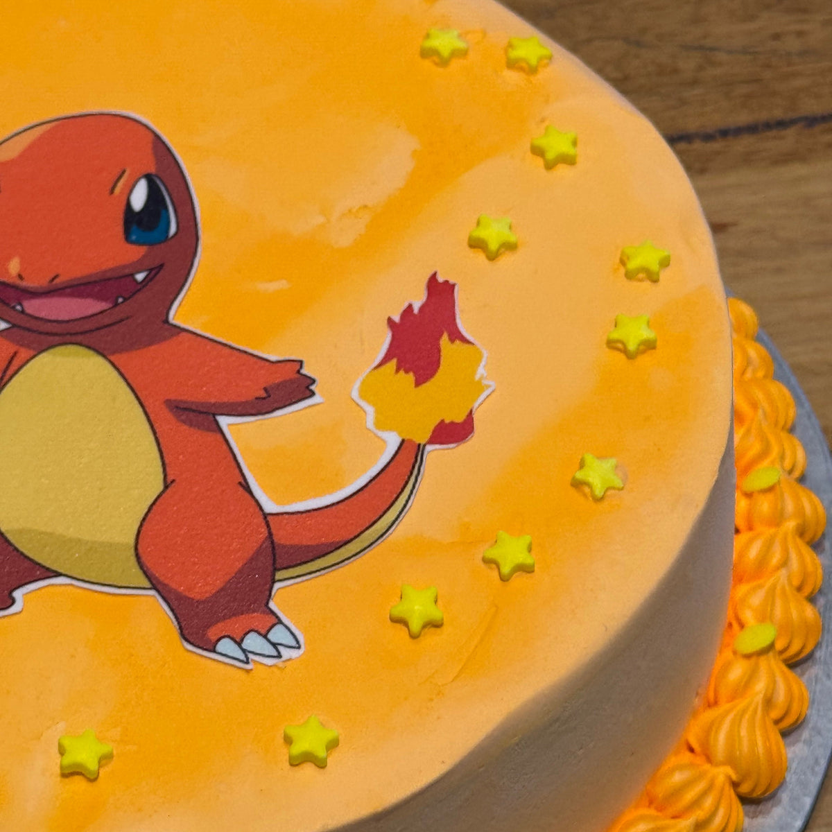Close-up of Charmander-inspired decorative details on a birthday cake made in Adelaide using Ben & Jerry's ice cream.