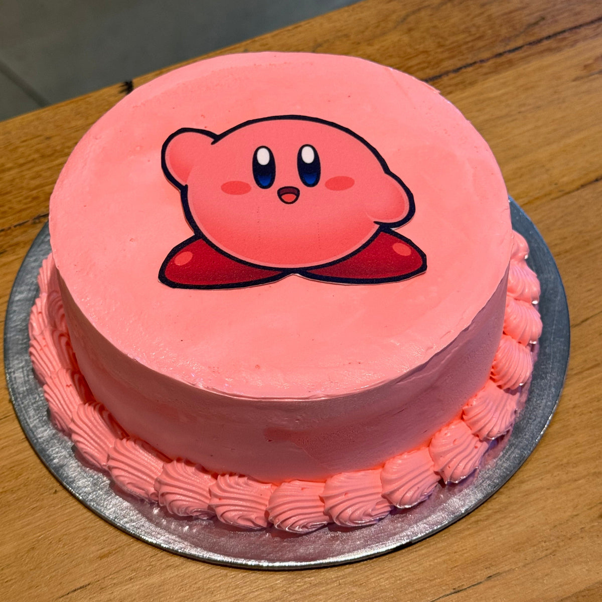 Full view of a pink Nintendo Kirby birthday cake handcrafted in Adelaide using Ben & Jerry's ice cream, featuring an adorable character-inspired design.