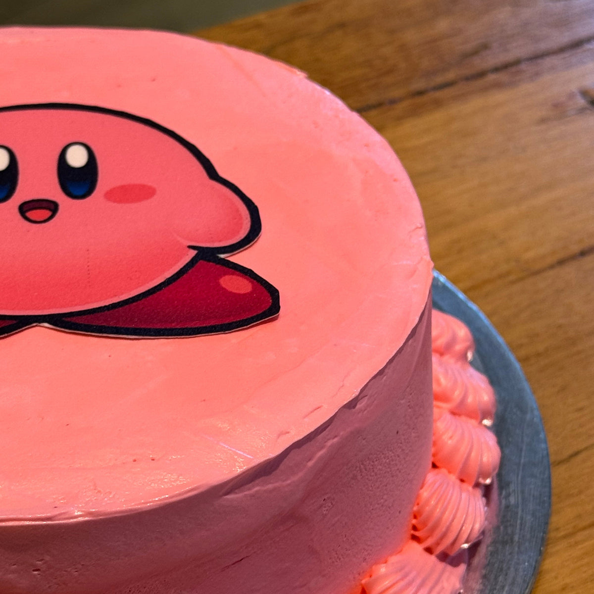 Side view of a pink Kirby ice cream cake handcrafted in Adelaide using Ben & Jerry's ice cream, highlighting its playful gaming theme.