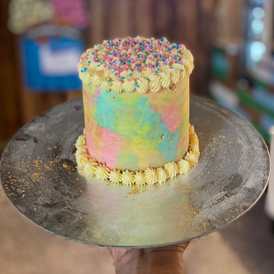 front view of a handcrafted rainbow confetti ice cream cake made using Ben & Jerry's ice cream in Adelaide, highlighting its impressive height and colourful design.