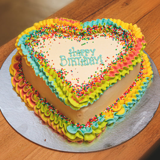Full view of a rainbow heart birthday ice cream cake featuring a colourful rainbow-inspired design and distinctive heart shape.