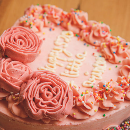 Close-up view of delicate rose-inspired decorations on a handcrafted heart-shaped birthday ice cream cake.
