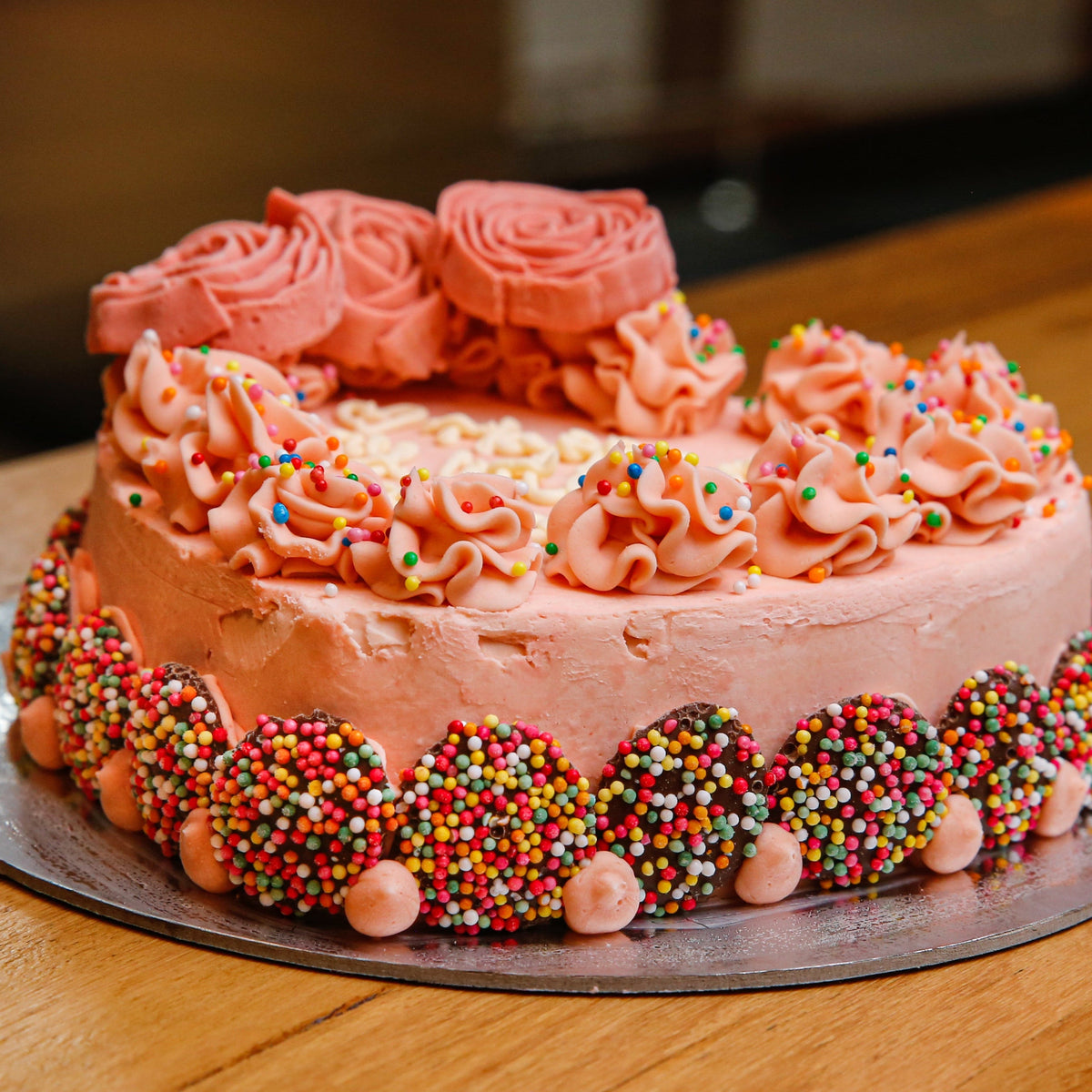 close up of a heart-shaped rose birthday cake highlighting its decorative floral finish and elegant celebration styling.