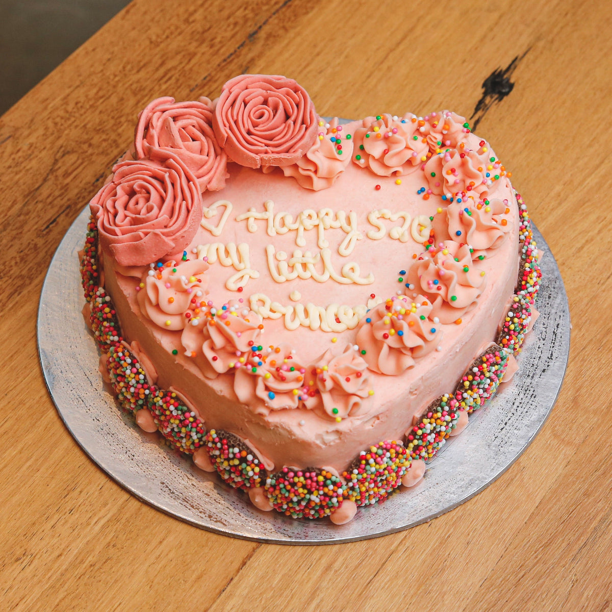 Full view of a heart-shaped roses birthday ice cream cake featuring romantic floral decorations for a special celebration.