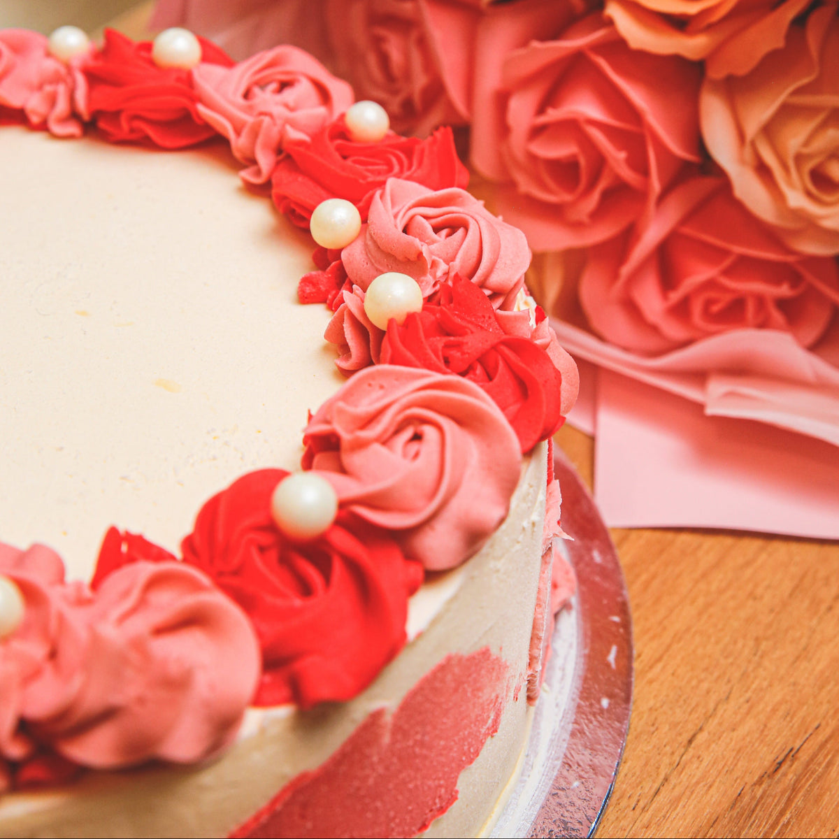 Close-up view of decorative roses and delicate pearl accents on a handcrafted birthday ice cream cake.