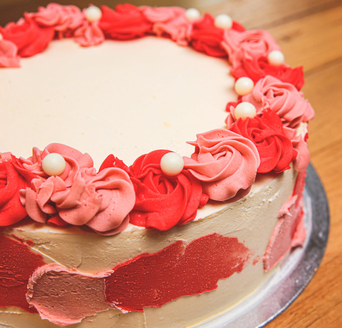 top view of an elegant roses and pearls birthday cake highlighting its floral decorations and pearl-inspired finishing details.