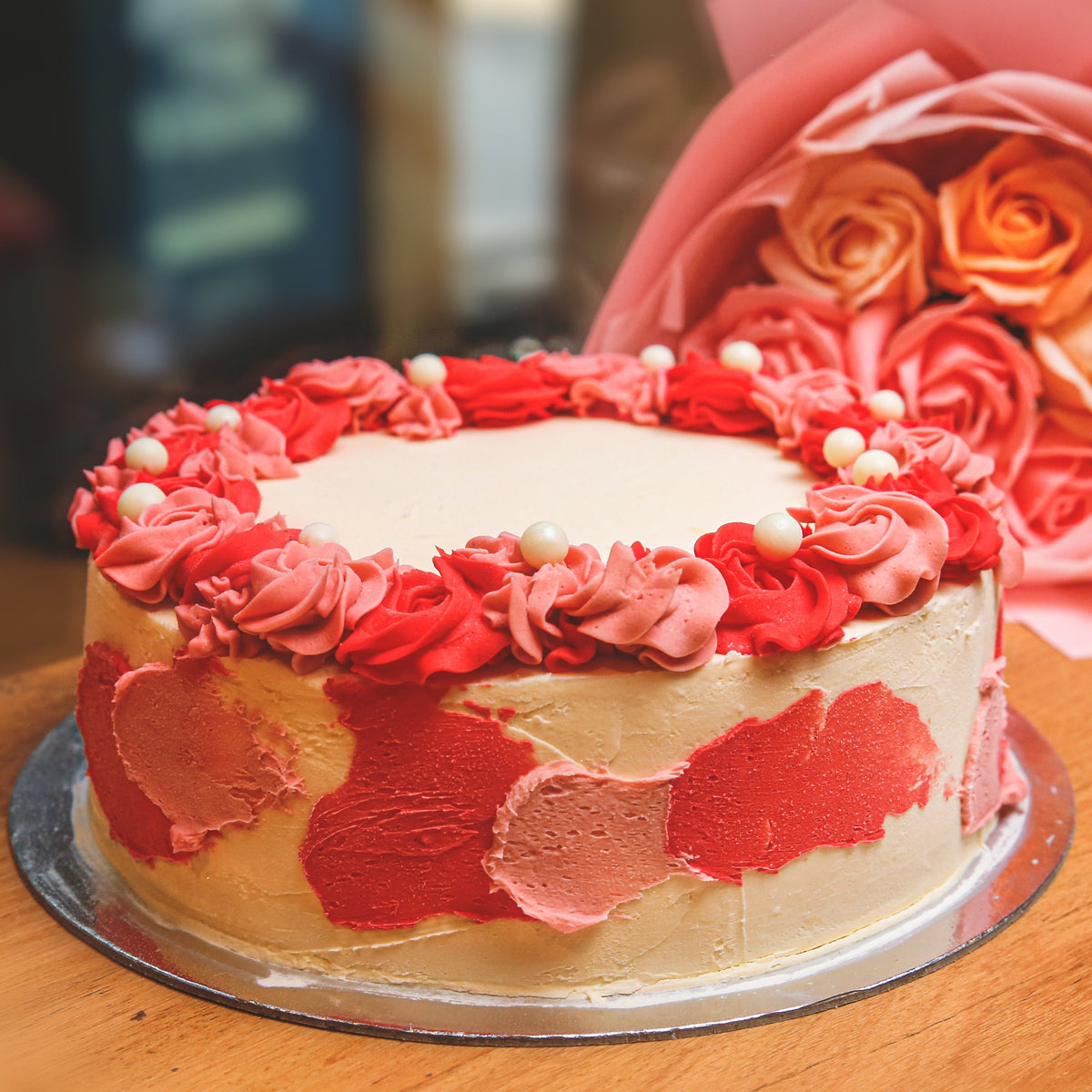 front view of an elegant roses and pearls birthday cake highlighting its floral decorations and pearl-inspired finishing details.