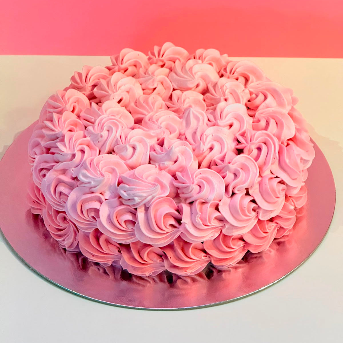 Full view of an elegant rosette birthday cake handcrafted in Adelaide using Ben & Jerry's ice cream, featuring beautiful floral-inspired decorative piping.
