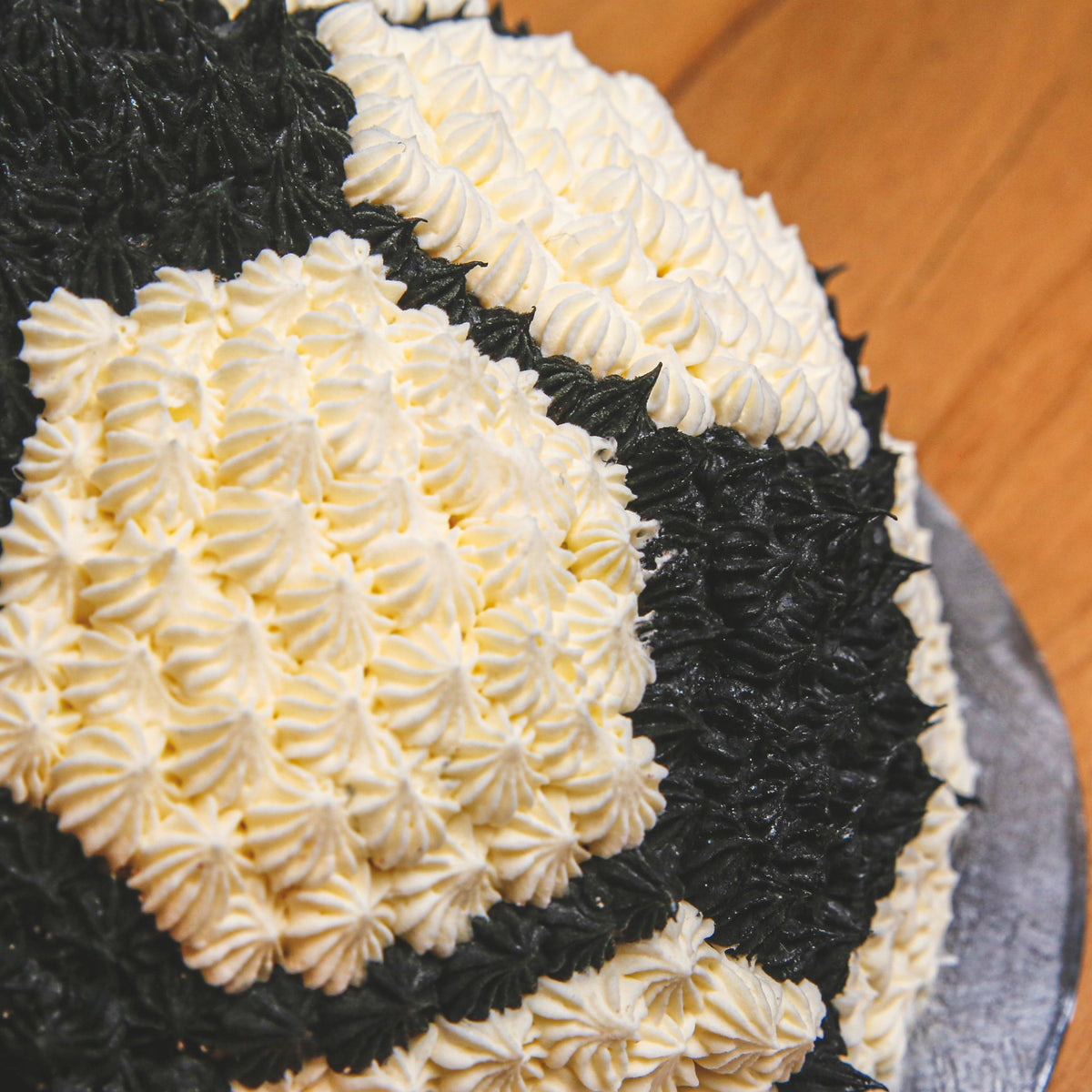 close up of a soccer ball birthday ice cream cake showcasing its realistic rounded dome shape and recognisable football panel design.