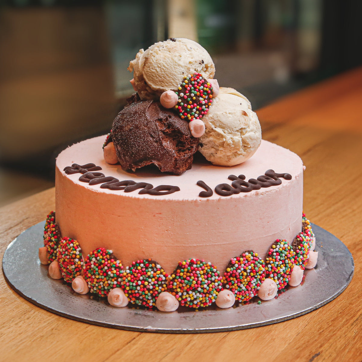 Front view of a Stacks On ice cream cake showcasing its stacked chocolate decorations and indulgent birthday cake presentation.