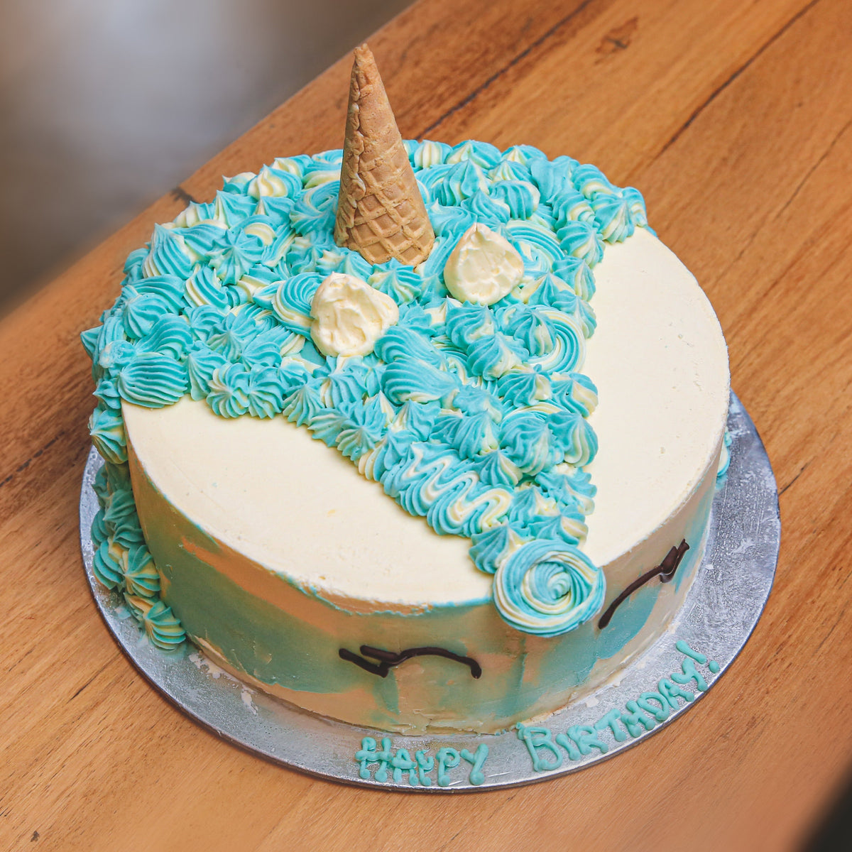 Full view of a round unicorn birthday ice cream cake featuring magical unicorn-inspired decorations for a children's birthday celebration.