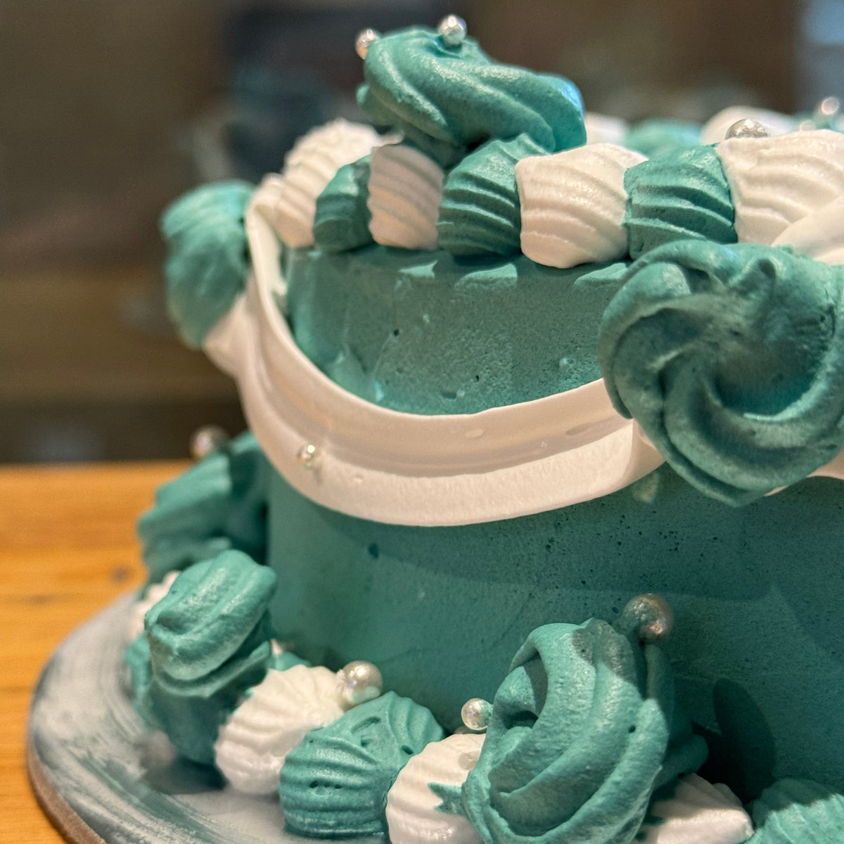 Close-up of intricate vintage-style piping on a romantic heart-shaped cake handcrafted in Adelaide using Ben & Jerry's ice cream.