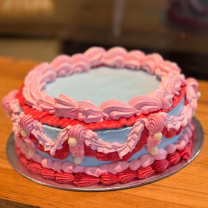 Full view of a pink, red and blue vintage birthday cake with pearl accents, handcrafted in Adelaide using Ben & Jerry's ice cream.