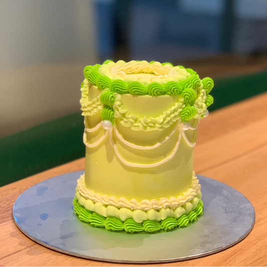 Full view of an elegant tall vintage birthday cake handcrafted in Adelaide using Ben & Jerry's ice cream, featuring classic decorative styling.