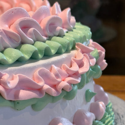 close up of a white and baby pink vintage cake made with Ben & Jerry's ice cream in Adelaide, showcasing its elegant decorative details.