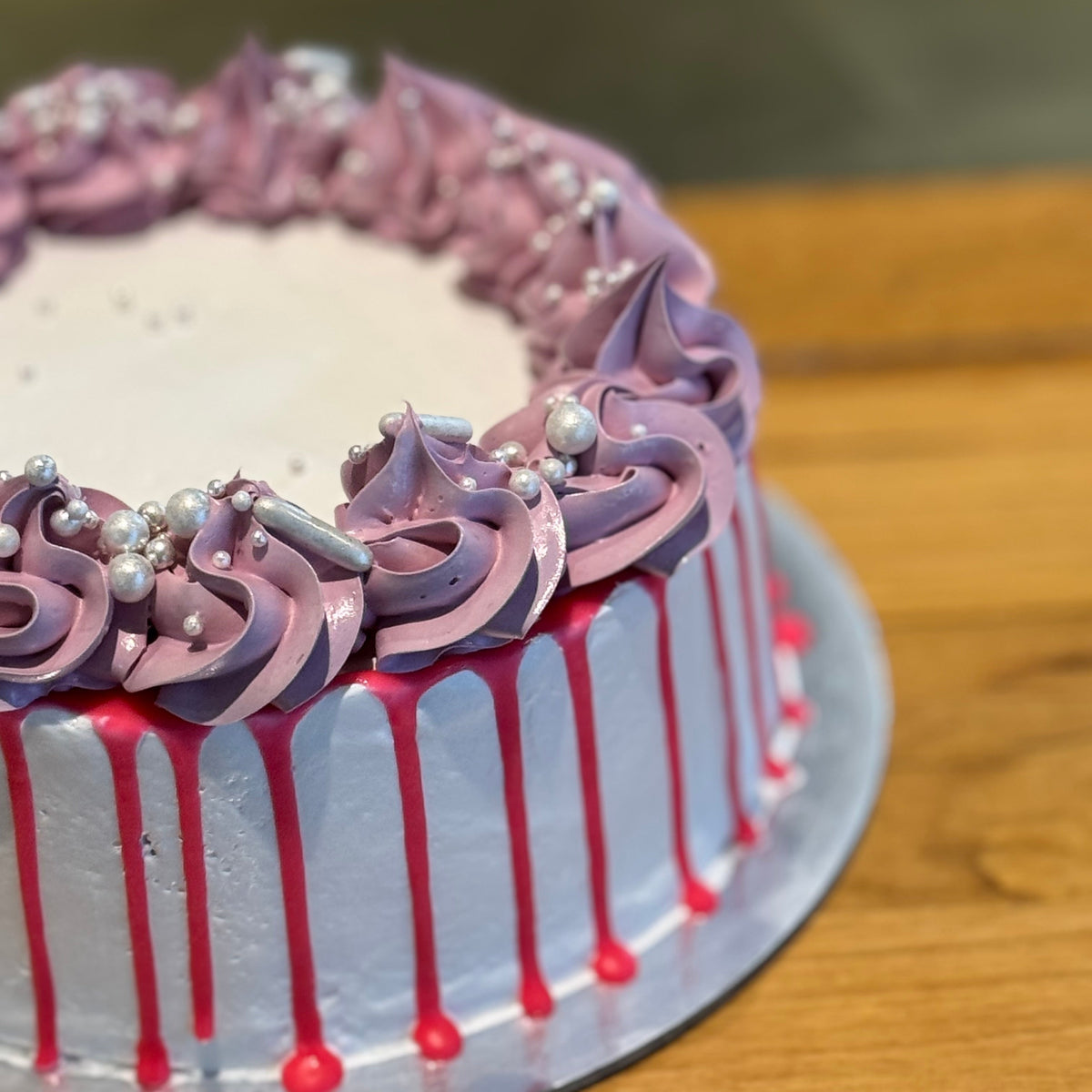 Side view of a vintage-inspired ice cream cake handcrafted in Adelaide using Ben & Jerry's ice cream, highlighting its soft pastel colours and piped details.