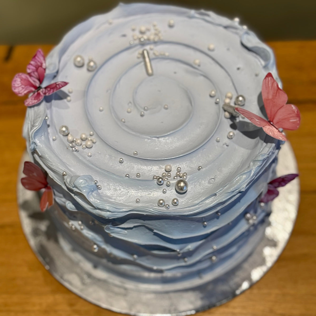 top view of a handcrafted mud or sponge cake in Adelaide, highlighting the flowing wave-effect texture and soft blue styling.